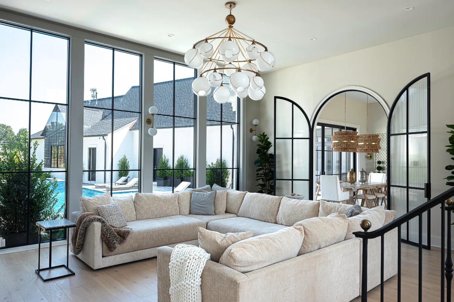 Living area with arched doorways, chandelier and garden windows in the Williamson Residence