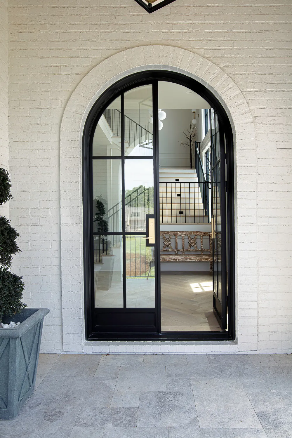 Arched black-framed entrance door at the Williamson Residence